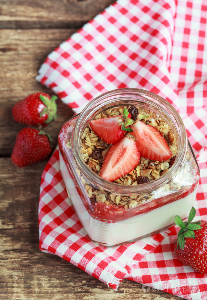 将自制酸奶放在一个装有草莓酱的罐子里