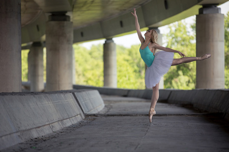 优雅的芭蕾舞演员做舞蹈练习对混凝土桥梁