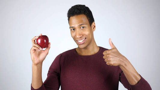 健康的生活方式，美国黑人男人出现红红的苹果和手势竖起大拇指