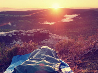 在自然界中的睡袋里睡觉。美丽的岩石中觉醒。查看从岩石峰