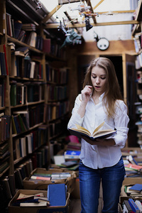 生活方式的一个可爱的学生女孩在老式图书馆或书店的肖像