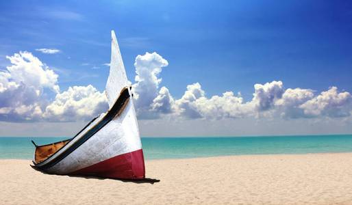 小木船在多云的蓝天下的海滩