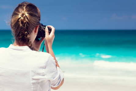 热带海滩拍照与无反光镜相机的女人