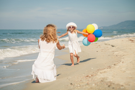 母亲和女儿在 da 在海滩上玩气球