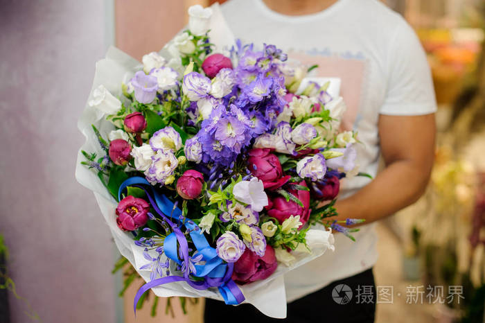 男人抱着美丽和多彩花束