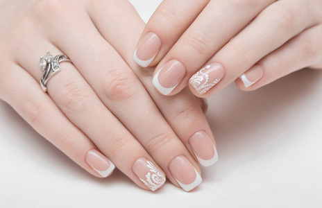 美丽的女性特写手应用透明指甲油在美容院健康自然女人指甲上.