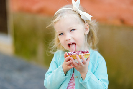 女孩吃新鲜的草莓蛋糕