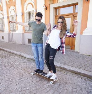 年轻夫妇骑滑板公园