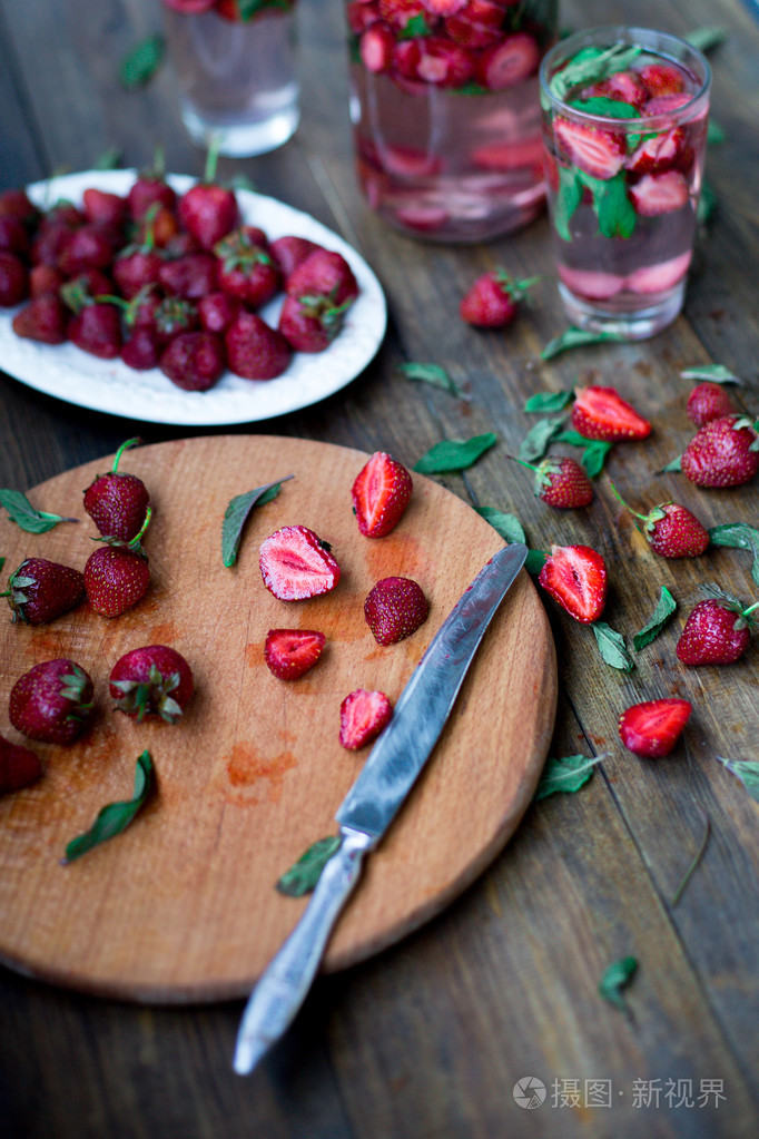 草莓薄荷注入水在黑色的木桌子背景下的乡村风格的装饰