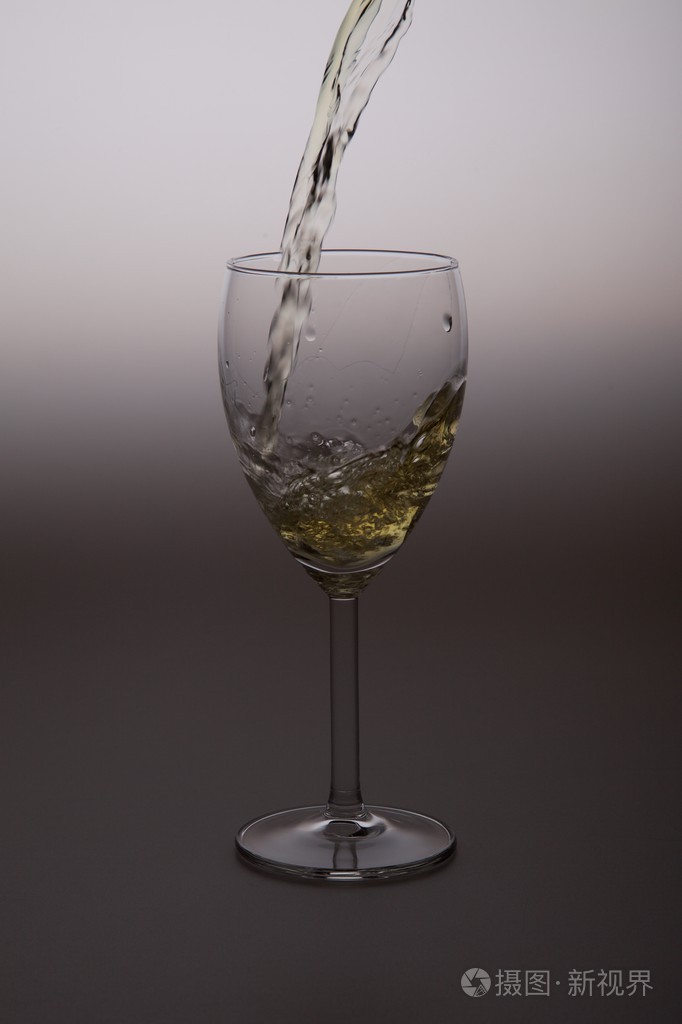 白葡萄酒被注入到清除玻璃酒杯