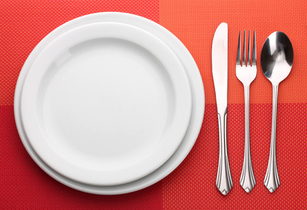 白空板与叉子 勺子和红色的桌布上刀