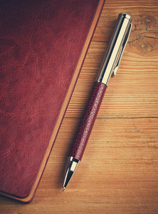 笔记本和钢笔在木材上