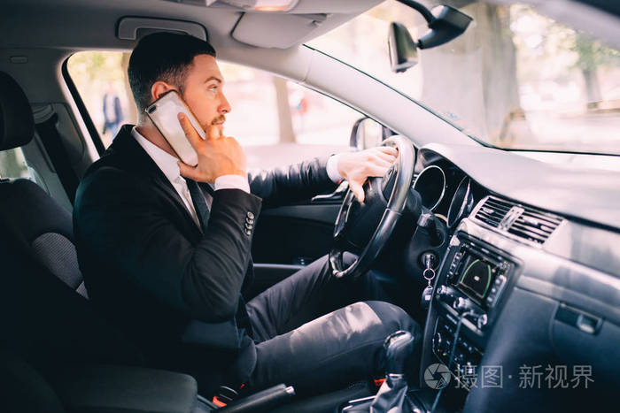 业务男司机讲电话白色开车