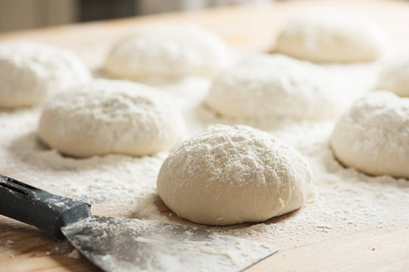 面团球上铺满了小麦粉准备烘烤用男性手中的面粉做成的圆形木筛,厨师