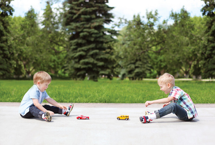 两个男孩儿童与玩具一起在户外玩在阳光明媚的 s