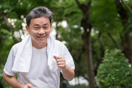 锻炼场景在自然公园户外场景中运行的快乐微笑的老人照片