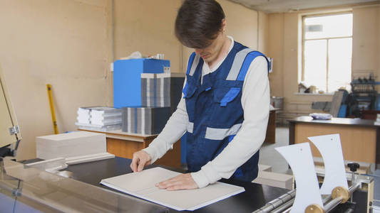 印刷厂的经营者在印刷机器工作图片