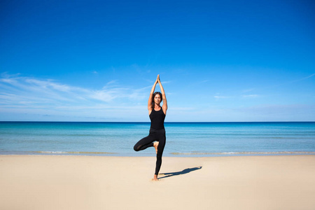 白色女孩放松体育在热带海滩上的冥想瑜伽