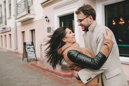 在城市的街头冬季拥抱对年轻的夫妇照片