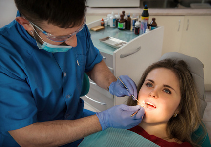 男牙医检查一个女人的孩子的牙齿