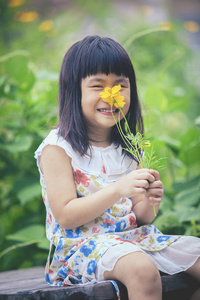 可爱的女孩，与黄波斯菊肖像花花束在汉