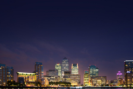 伦敦金丝雀码头夜晚，泰晤士河有灯光反射