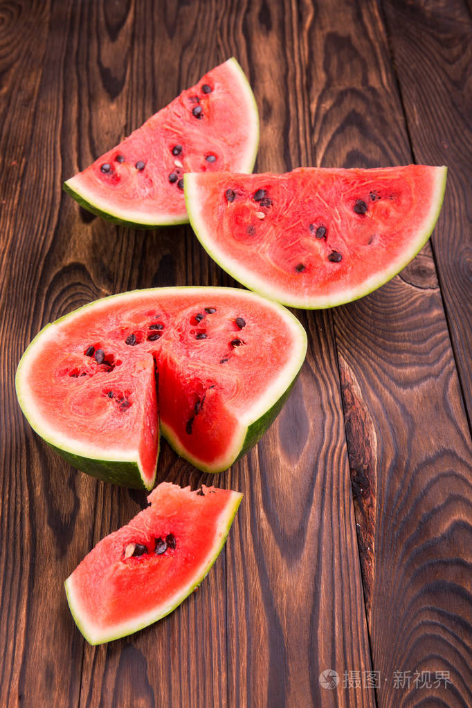 西瓜上深色的棕色木制背景的两半一个特写镜头的甜蜜新鲜生和熟的西瓜