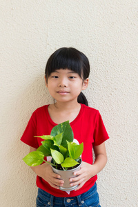 小女孩抱着盆栽的植物图片