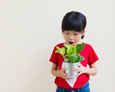 小女孩抱着盆栽的植物图片