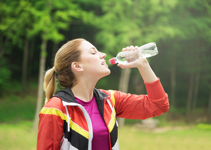 有魅力的运动女人喝水。