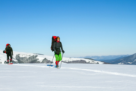 在山里徒步旅行带着背包和帐篷雪的冬天