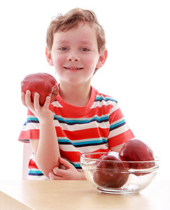 小男孩抱着一个大的红苹果，特写