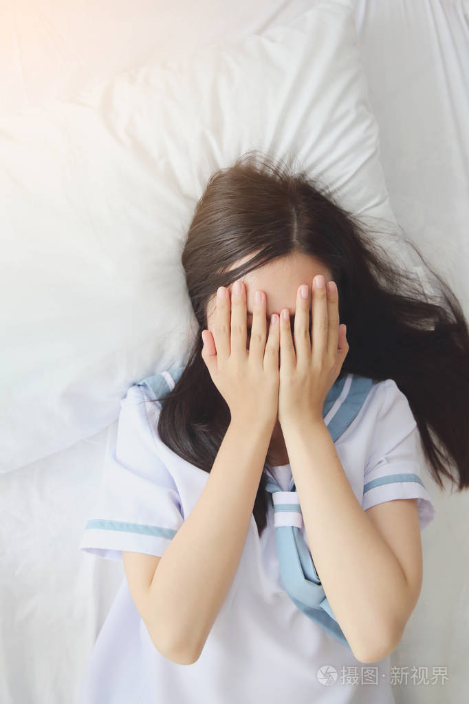 学校女孩微笑和害羞上白色的房间里