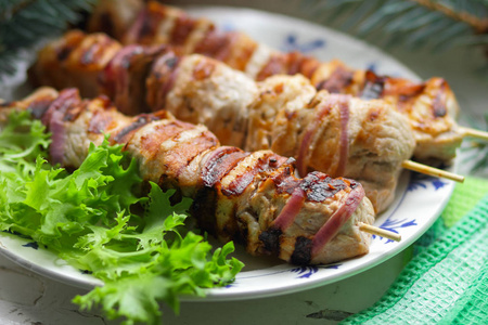 冷杉的枝条 罗文与绿叶生菜猪肉肉串烤熟在烤架上吃圣诞大餐设计器