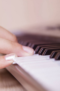 漂亮的女孩手玩电子钢琴键盘