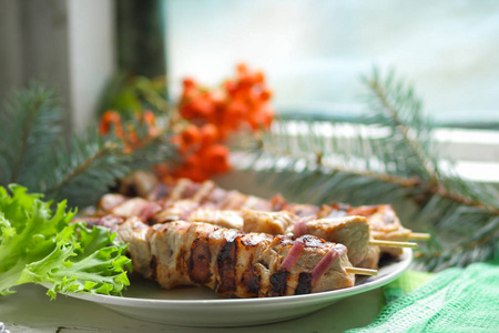 冷杉的枝条 罗文与绿叶生菜猪肉肉串烤熟在烤架上吃圣诞大餐设计器