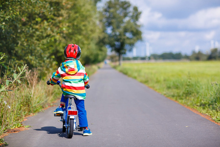 孩子在头盔骑他的第一辆自行车，在户外的男孩