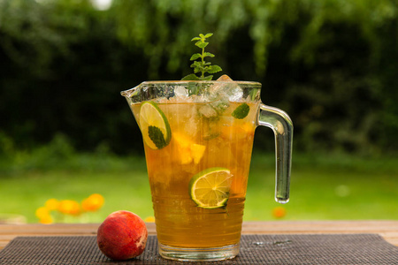 自制桃冰茶与石灰和柠檬香蜂草照片