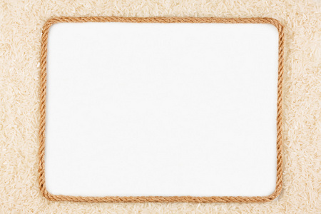 框架的绳子用大米制成躺在白色的背景上照片