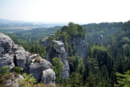 高大的岩石四周茂密的森林，在捷克共和国捷克天堂里的蓝色天空下的视图