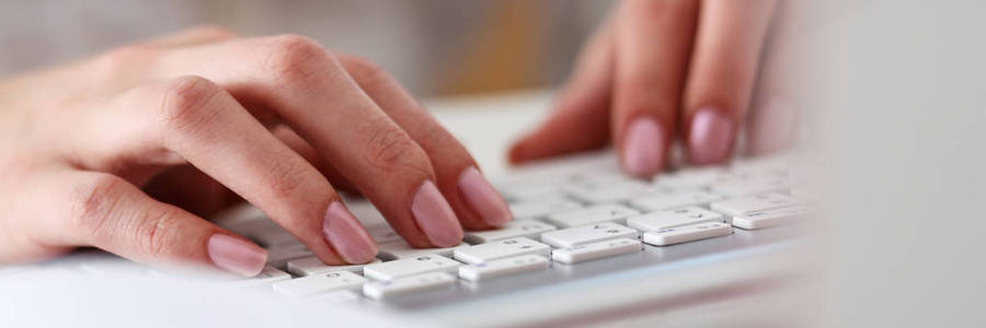 在使用计算机 pc 的银色键盘上打字的女性手