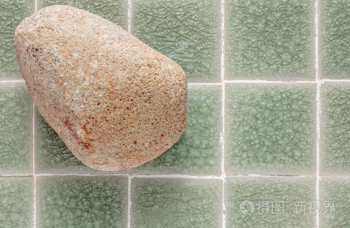 皮肤磨砂膏石头在绿色马赛克背景