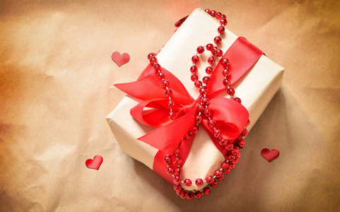 礼品盒用红色的心，在旧的桌子上。情人节