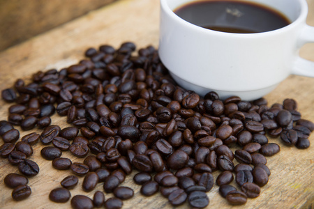 喝咖啡豆背景上木，新鲜的咖啡豆咖啡杯上木制的背景，设置背景