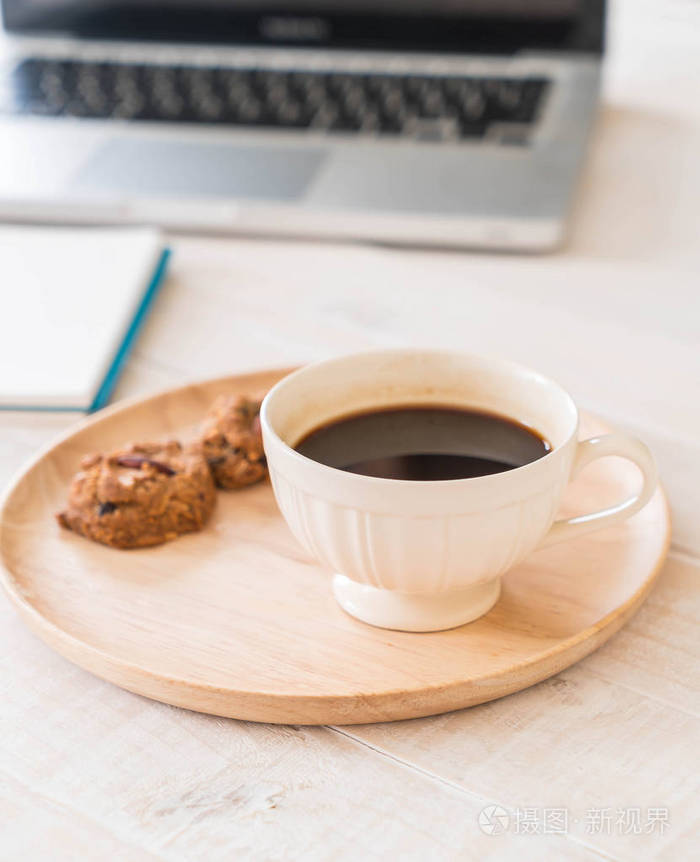 黑咖啡和饼干与笔记本电脑和注书
