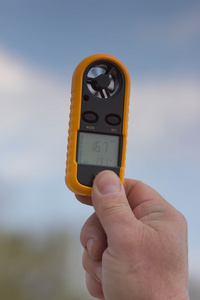 风速仪在男人,风速 16.7 女士的手.clouse 向上照片