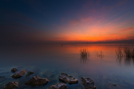 岩石和意大利在橙色夕阳红湖草