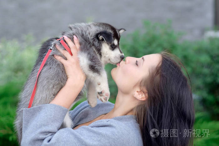 微笑的女士抱着可爱的哈士奇小狗