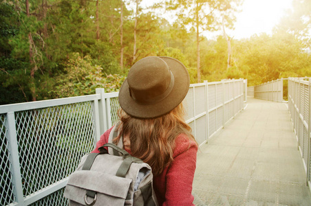 女人旅行背包和帽子走在令人惊叹的走道