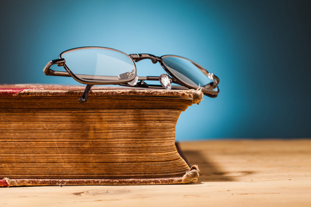老书和木制的桌子上的眼镜